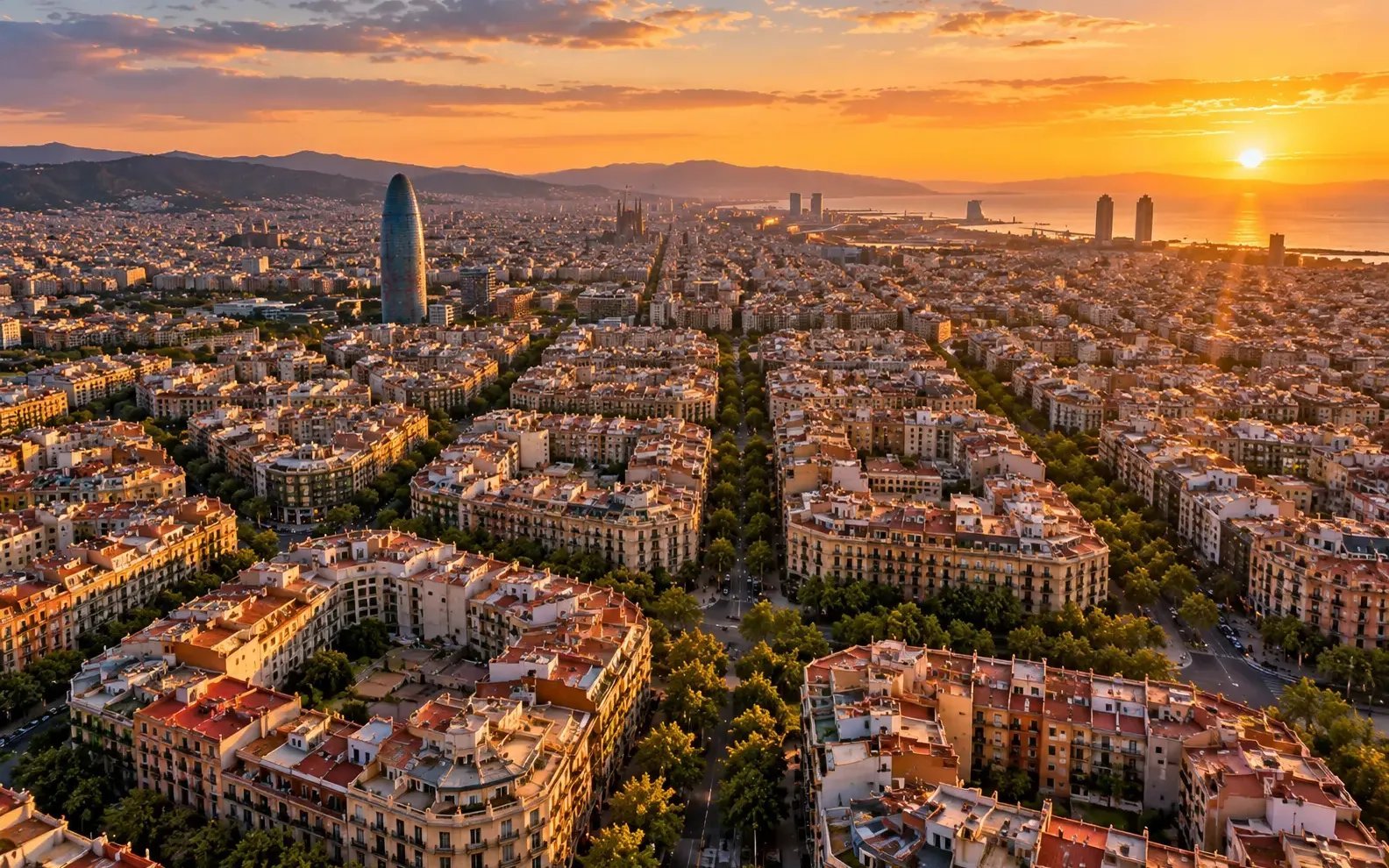 Vista aérea del Eixample de Barcelona con su cuadrícula urbana y la Torre Glòries al atardecer